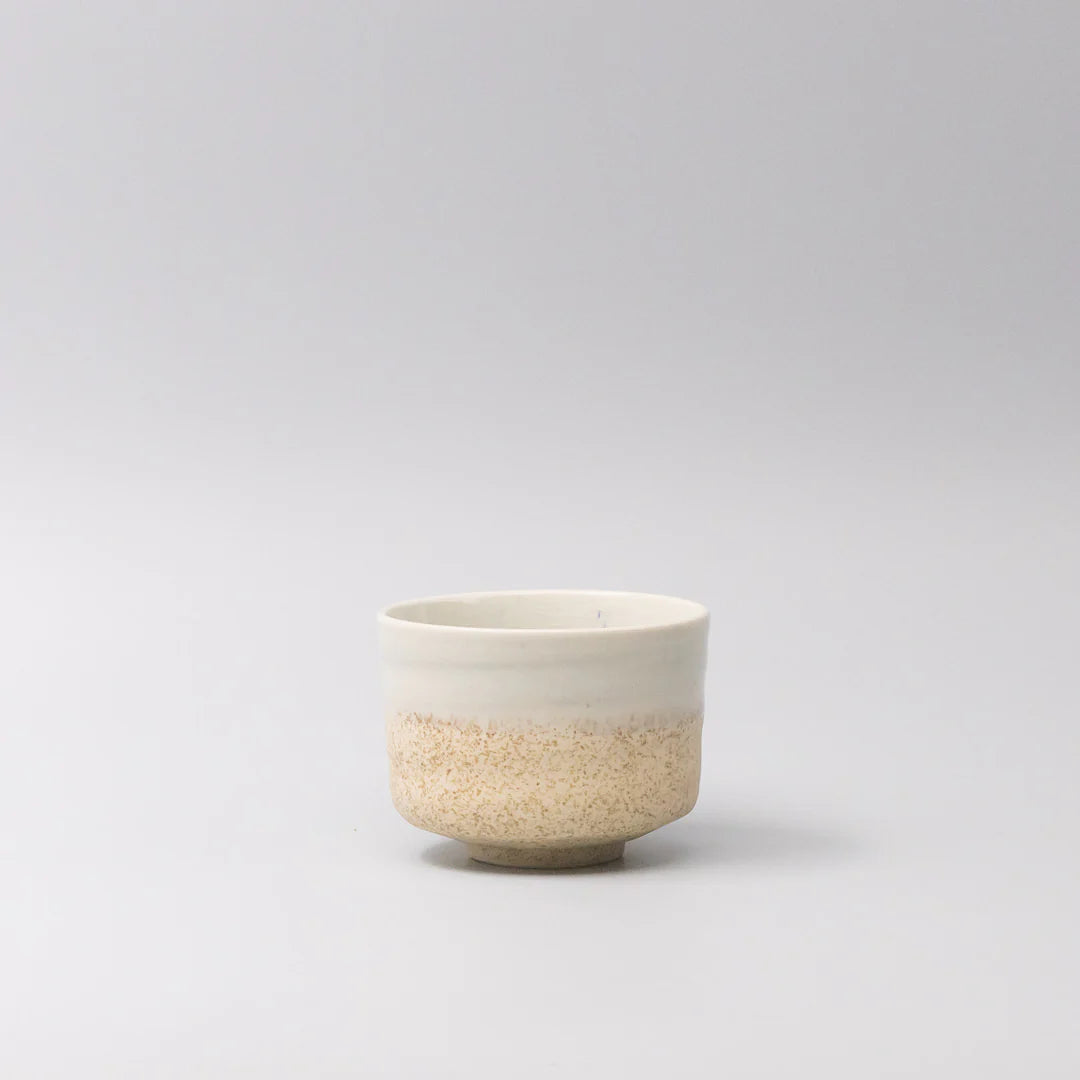 Ceramic cup with two-tone design on a light gray background