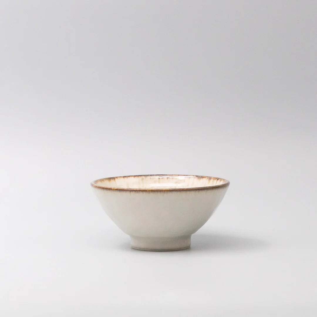 Small ceramic bowl with gold rim on a light gray background