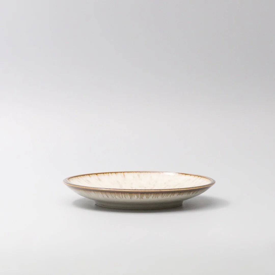 Ceramic plate with a gold rim on a light gray background