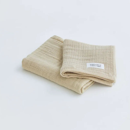 Folded beige towel with a label on a white background