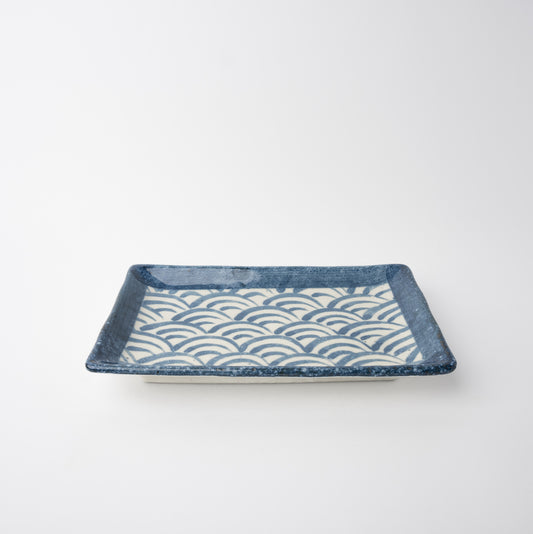 Rectangular ceramic tray with wave pattern on a white background