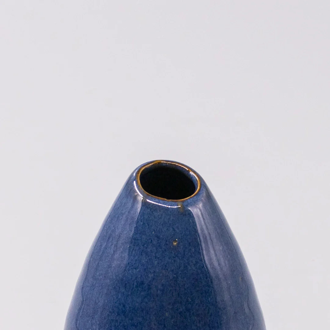 Blue ceramic vase on a light gray background