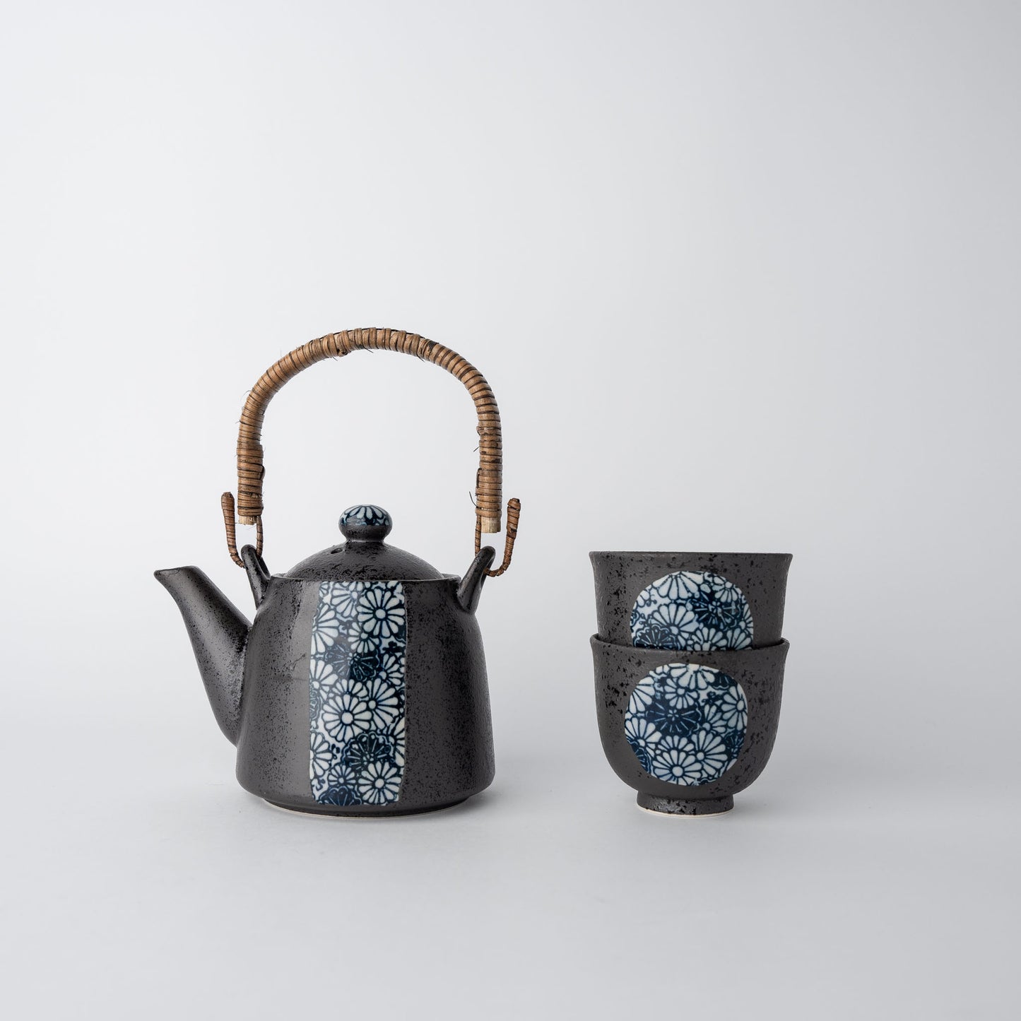 Ceramic teapot and cup with floral patterns on a white background