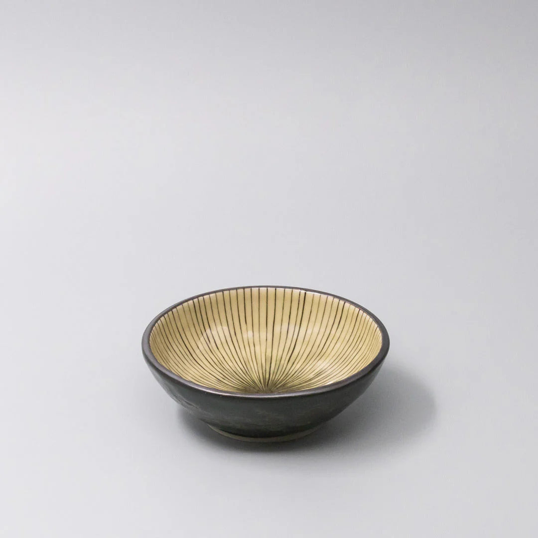 Ceramic bowl with gold interior on a gray background