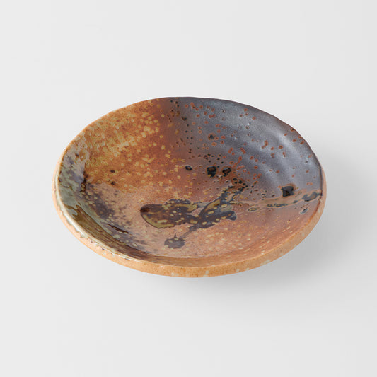 Ceramic bowl with brown and black speckled glaze on a white background