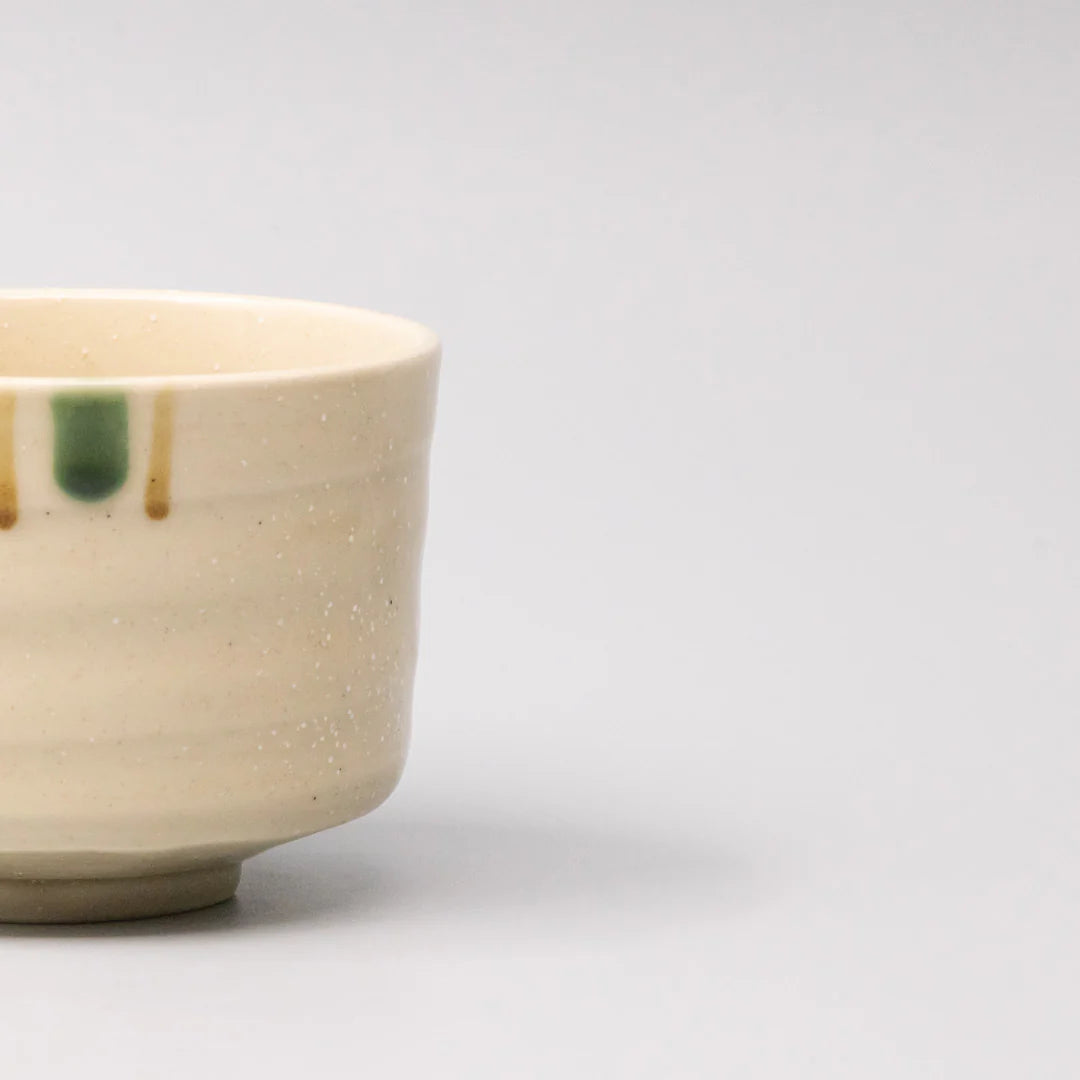 Close-up of a ceramic cup with speckled texture on a light gray background