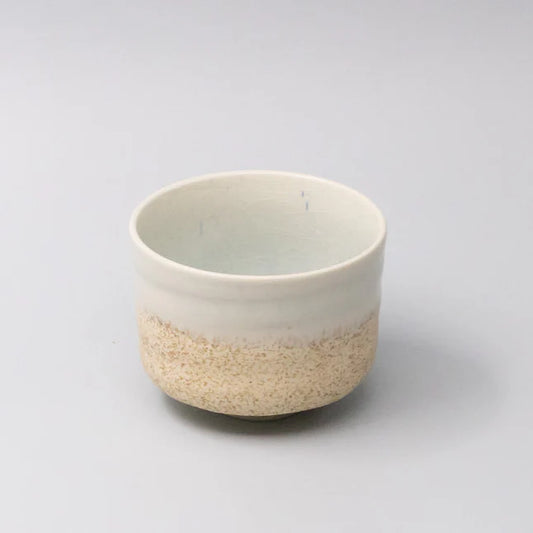 Ceramic cup with two-tone design on a light gray background