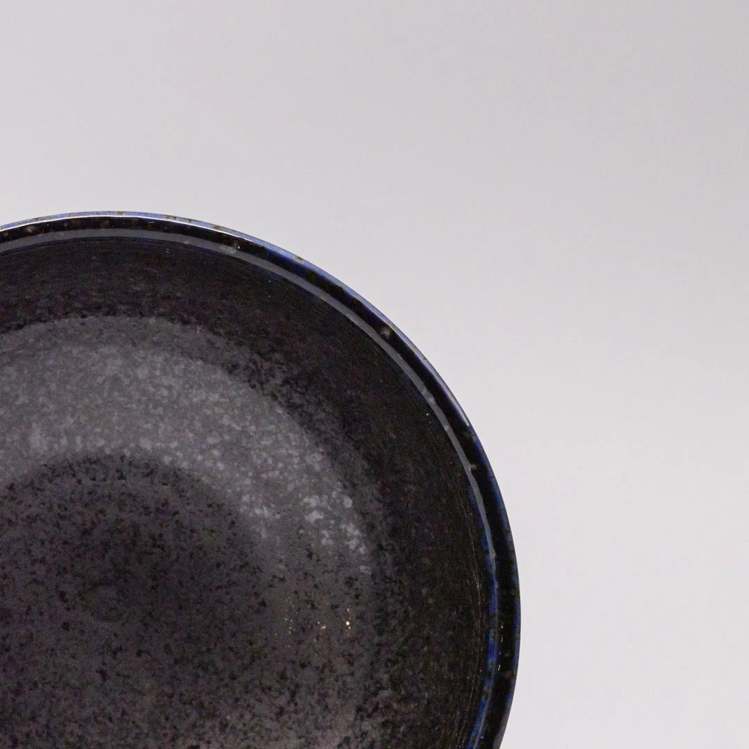 Close-up of a black ceramic bowl on a light gray background