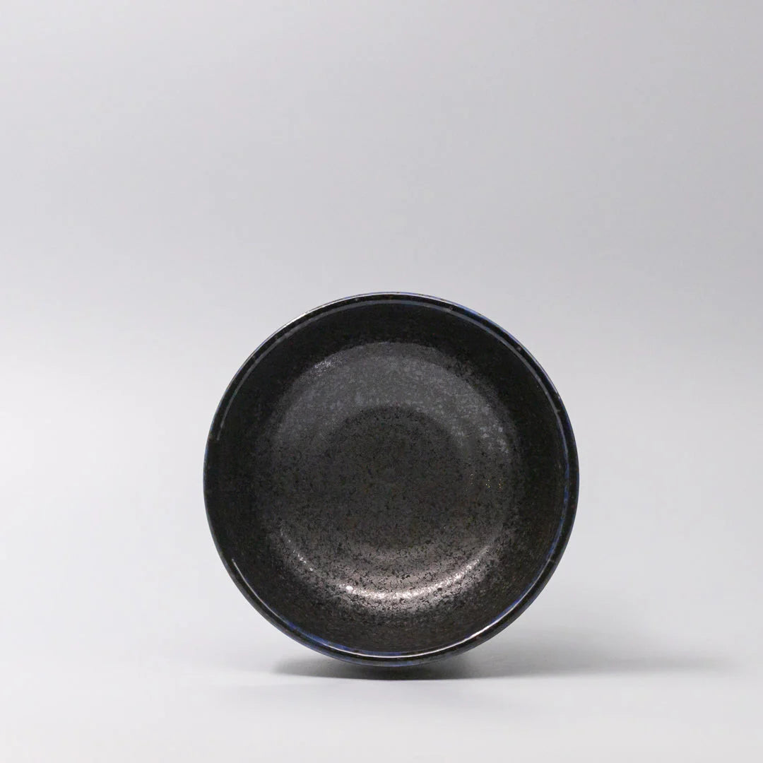Black ceramic bowl on a light gray background