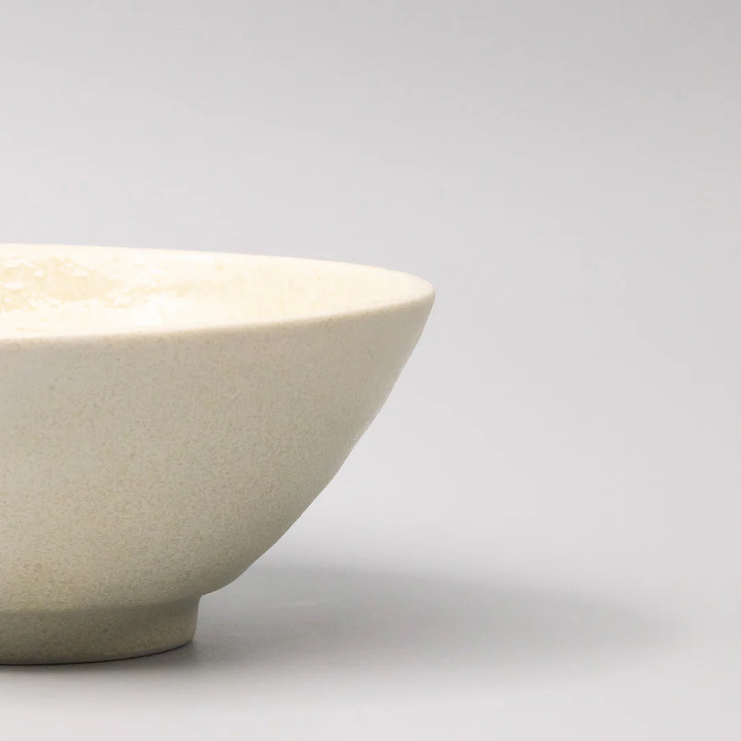 Beige ceramic bowl on a light gray background