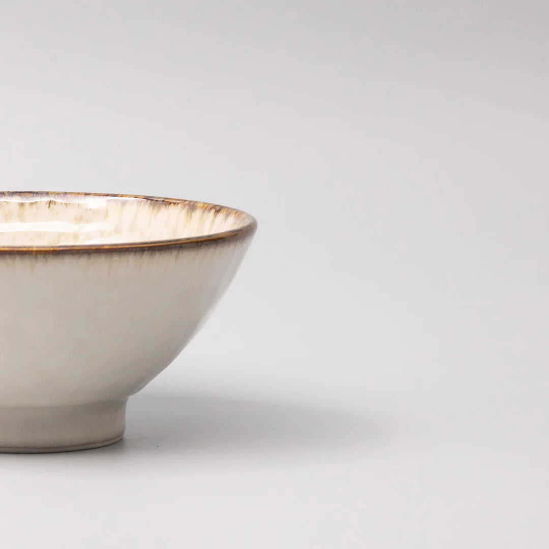 Ceramic bowl with a gold rim on a light gray background