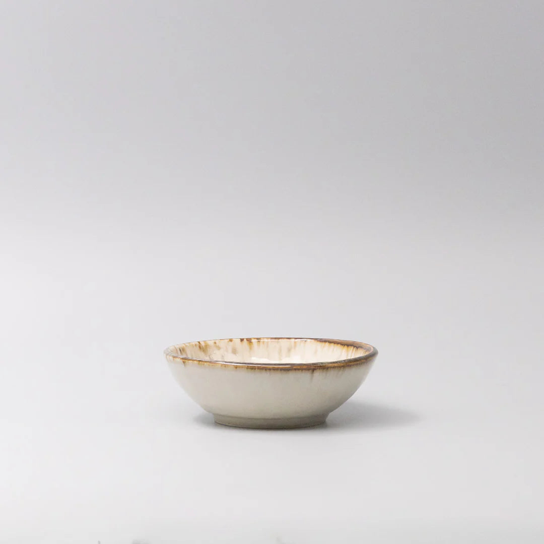 Small ceramic bowl with gold interior on a light gray background