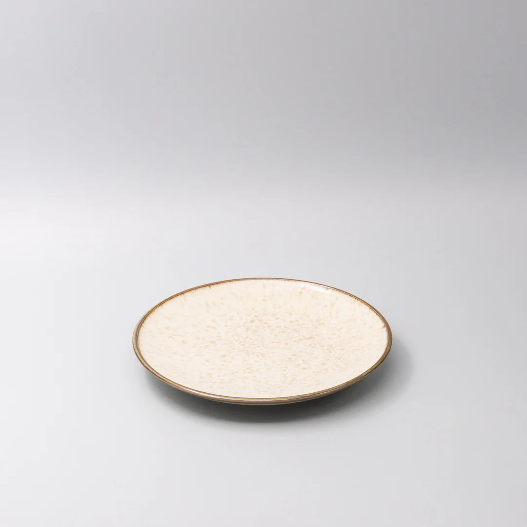 Round ceramic plate with textured surface on a gray background