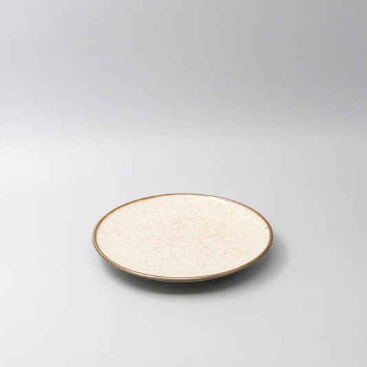 Round ceramic plate with textured surface on a gray background