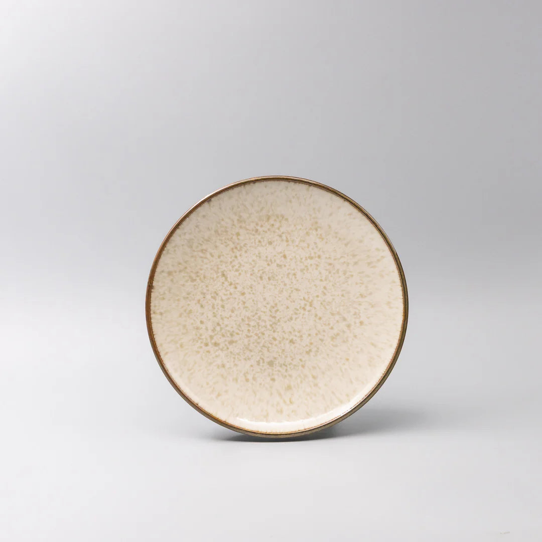 Round ceramic plate with a textured surface on a gray background