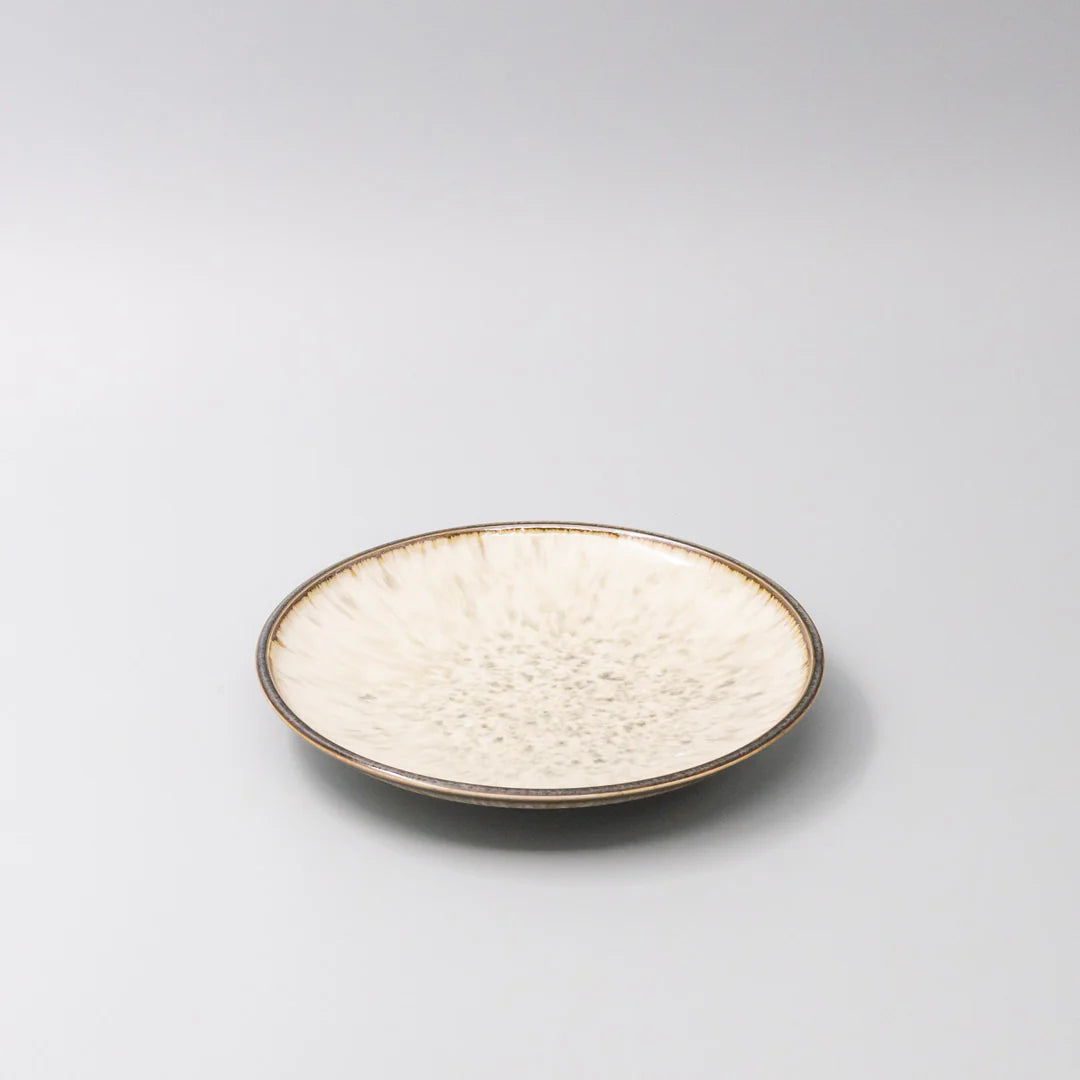 Round ceramic plate with textured surface on a light gray background