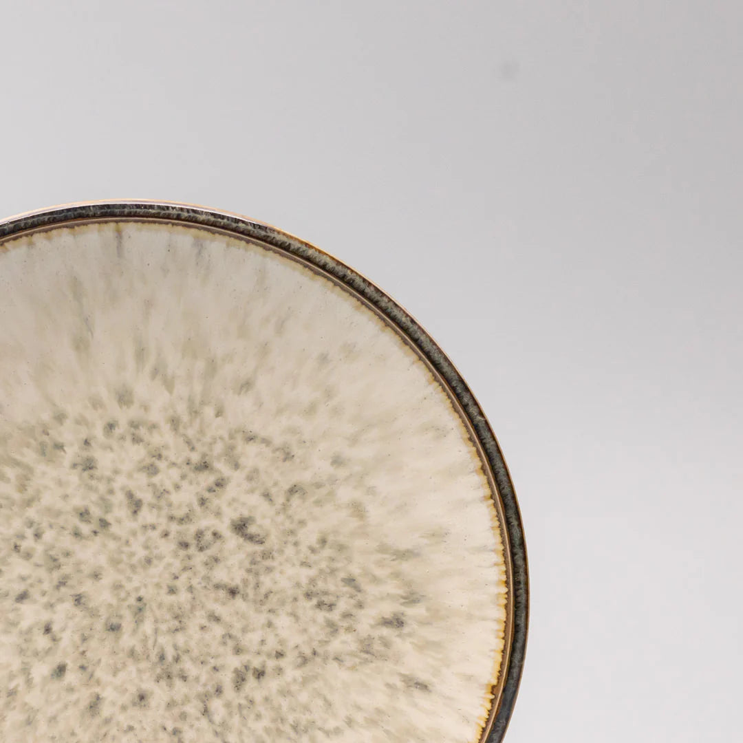 Close-up of a ceramic plate with textured surface on a light gray background