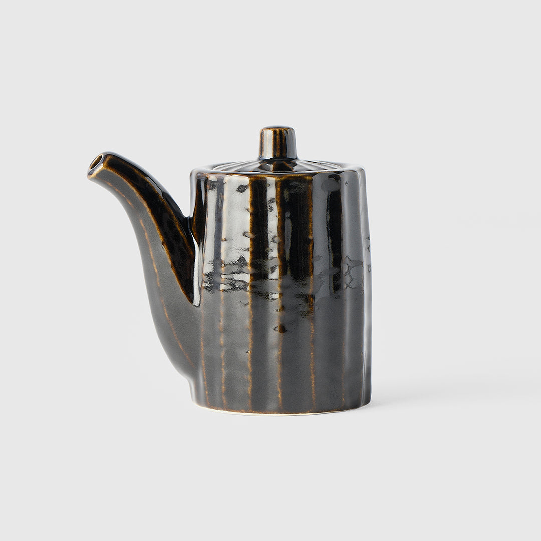 Black ceramic teapot on a light gray background