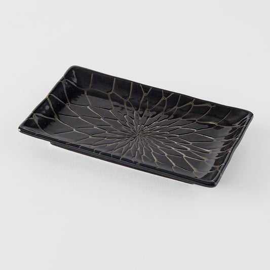 Black rectangular ceramic tray with decorative pattern on a white background