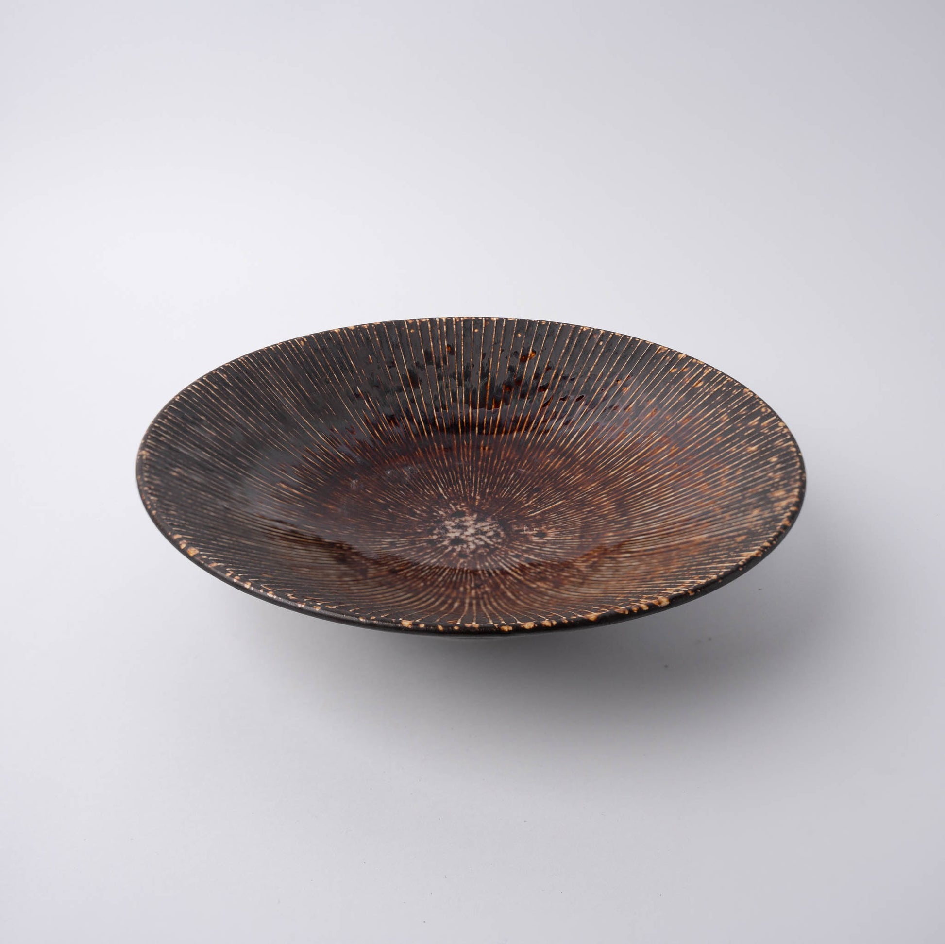 Decorative ceramic bowl with textured surface on a white background