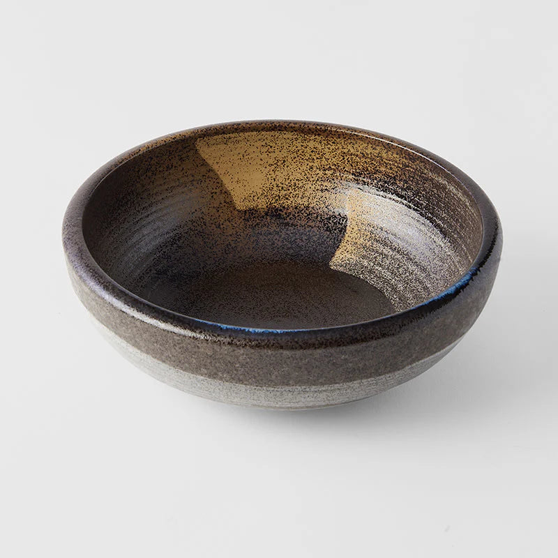 Ceramic bowl with speckled brown and beige design on a light gray background