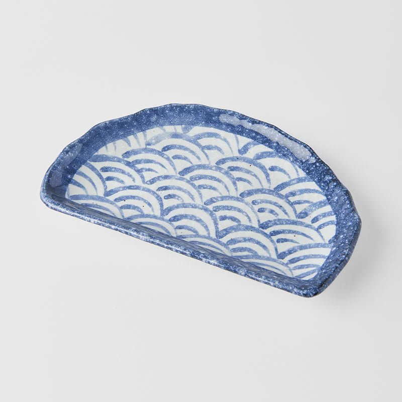 Blue and white ceramic tray with wave pattern on a light gray background