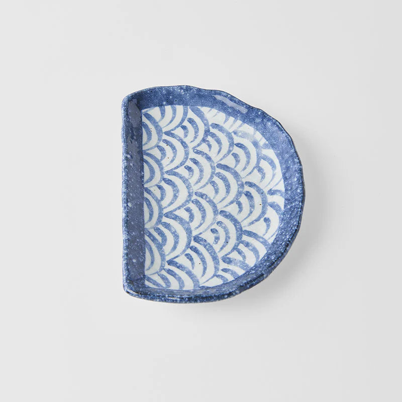 Blue and white patterned half-circle dish on a light gray background