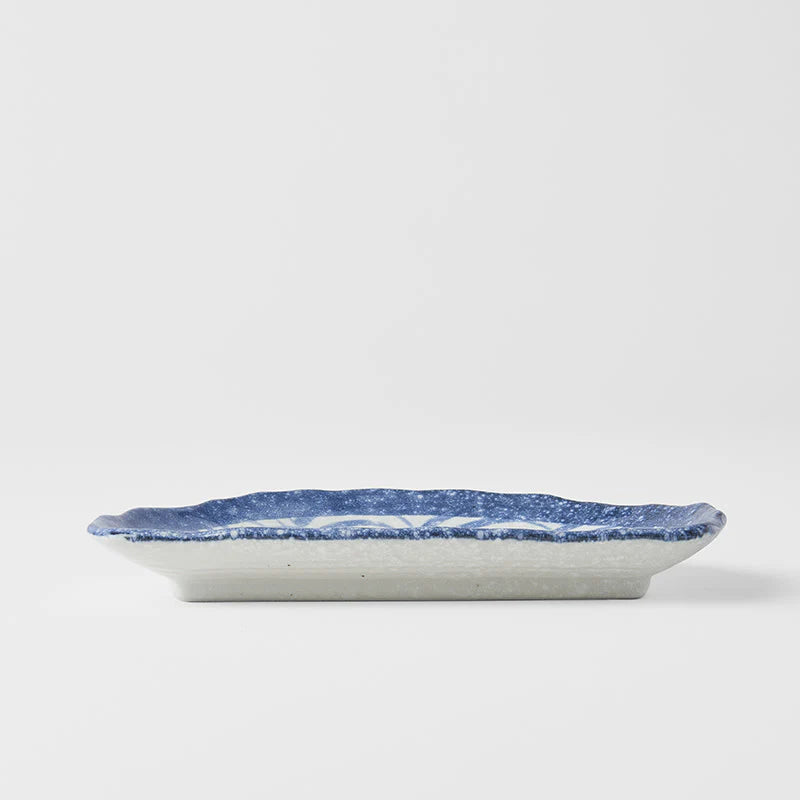 Ceramic plate with blue speckled pattern on a white background