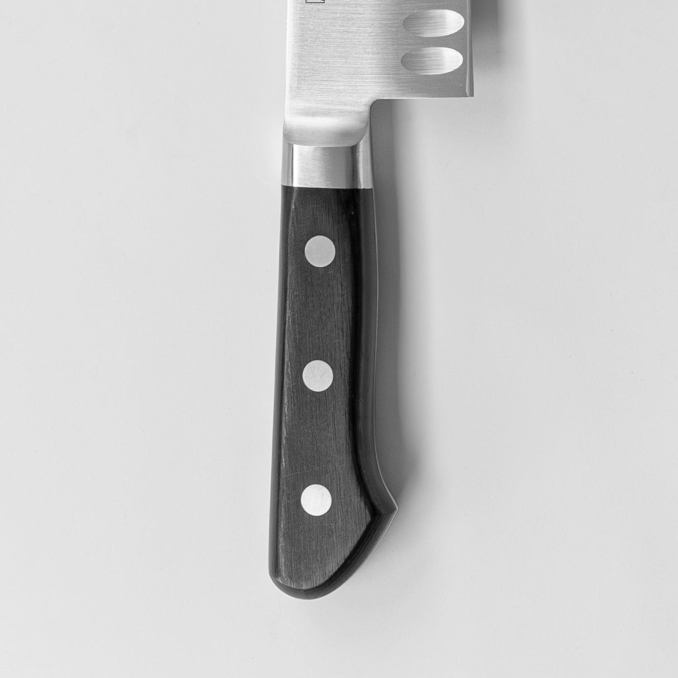 Chef's knife with a black handle on a light gray background