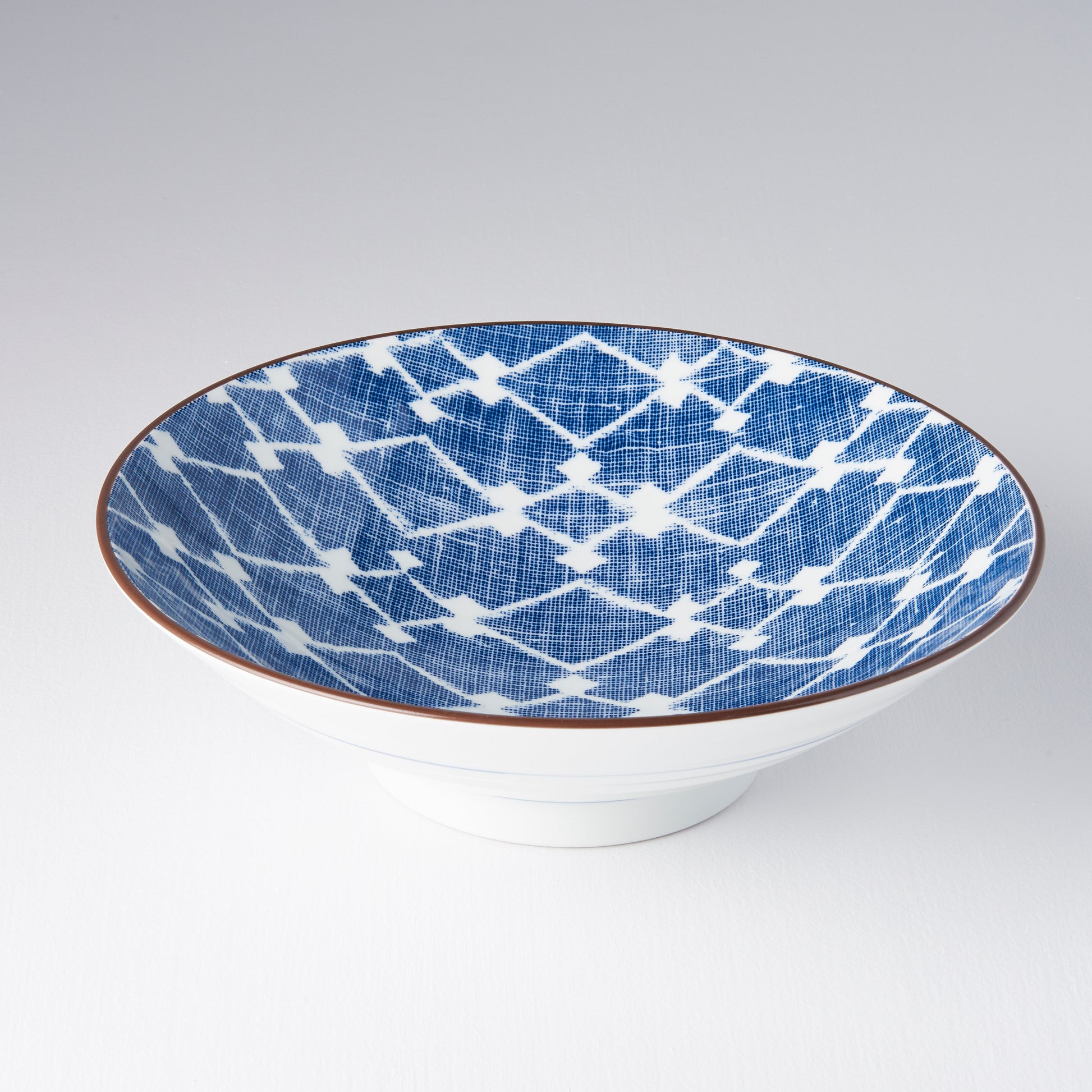 Ceramic bowl with blue and white geometric pattern on a white background