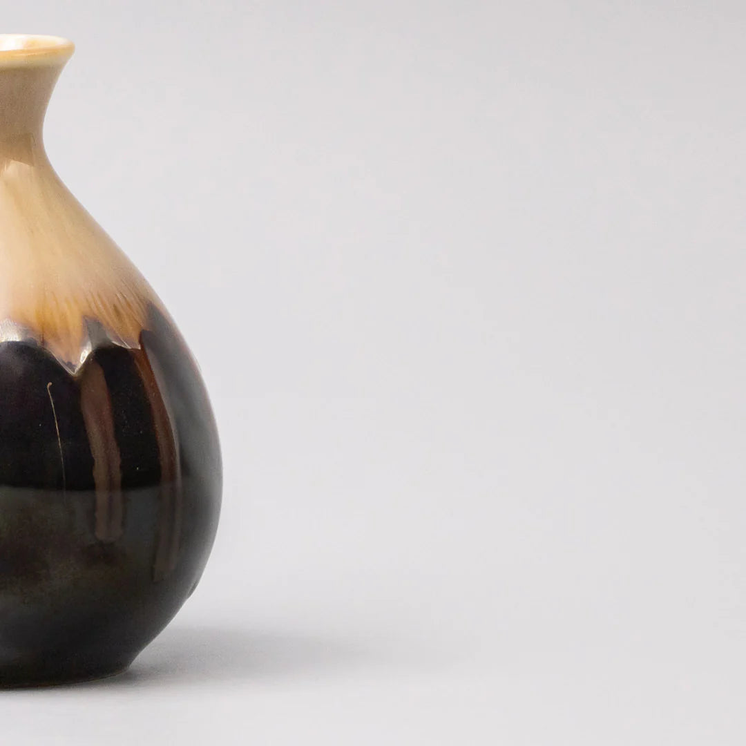 Ceramic vase with brown and beige gradient on a light gray background