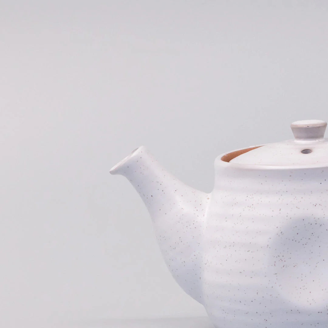 White ceramic teapot on a light gray background