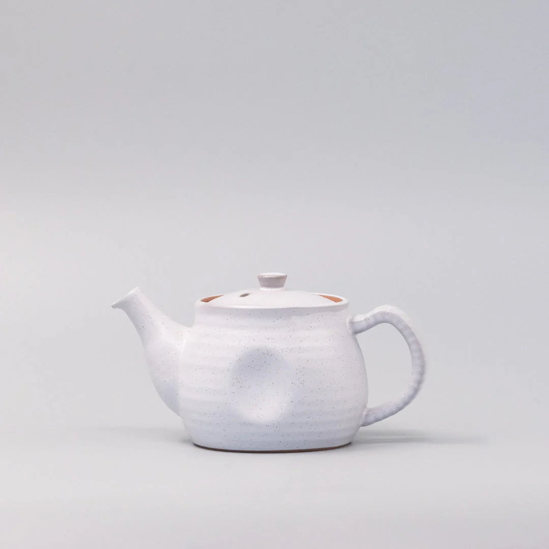 White ceramic teapot on a light gray background
