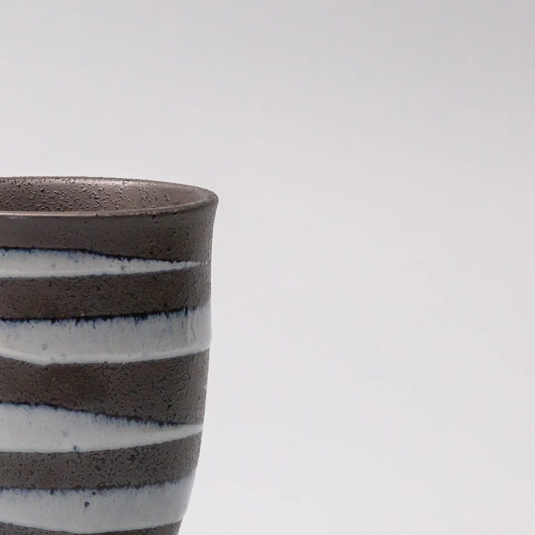 Ceramic cup with striped design on a white background