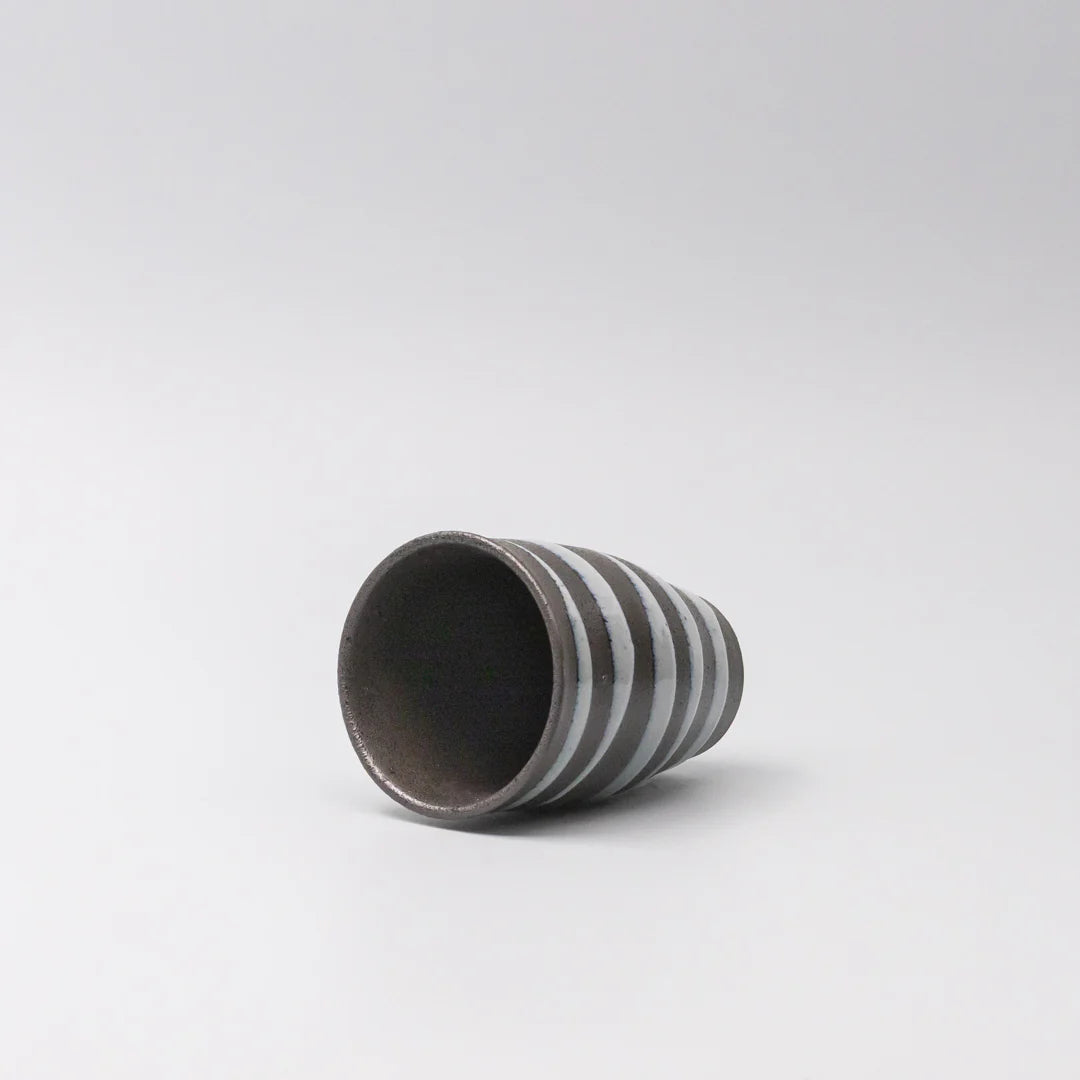 Cylindrical ceramic vase with striped pattern on a white background
