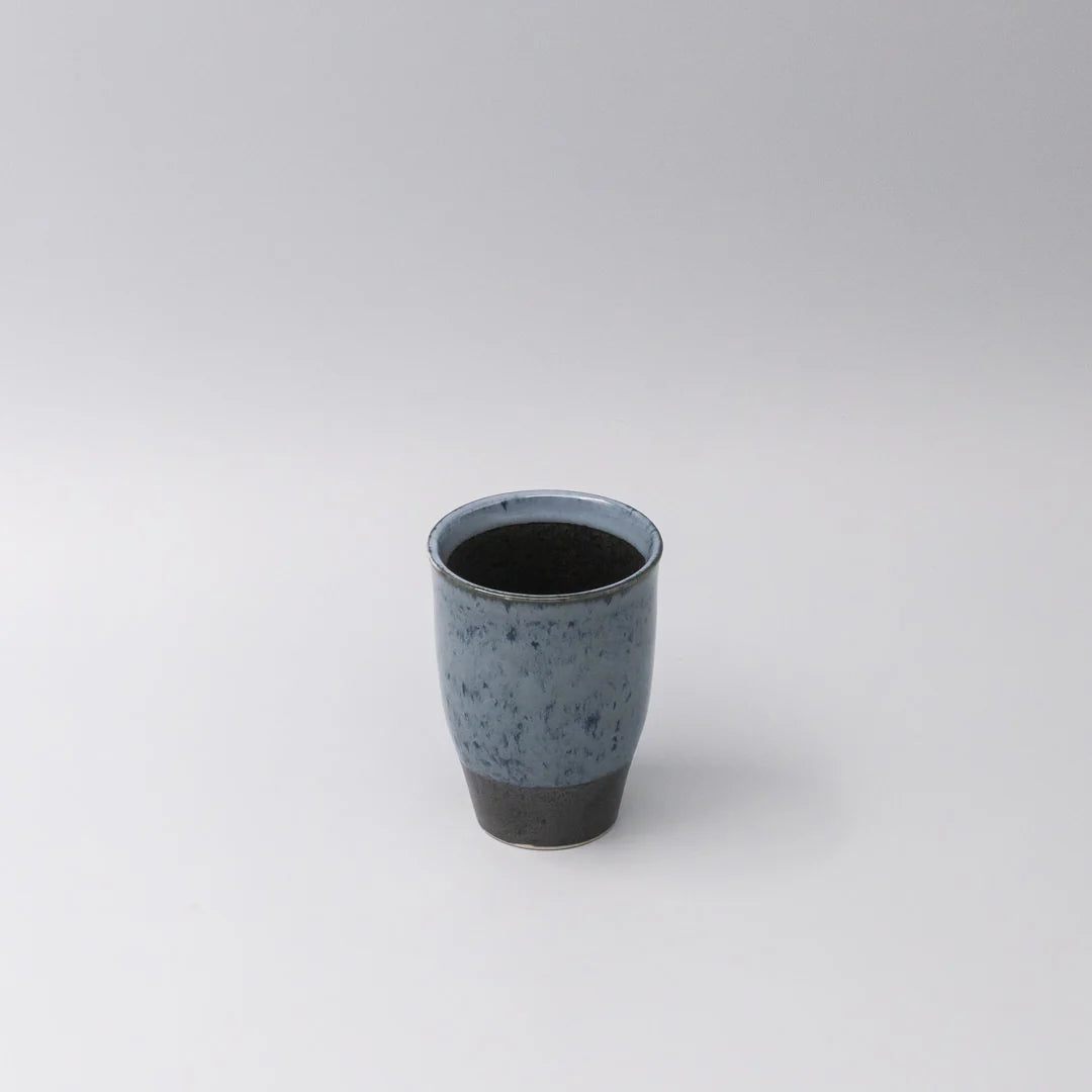 Ceramic cup with speckled design on a white background