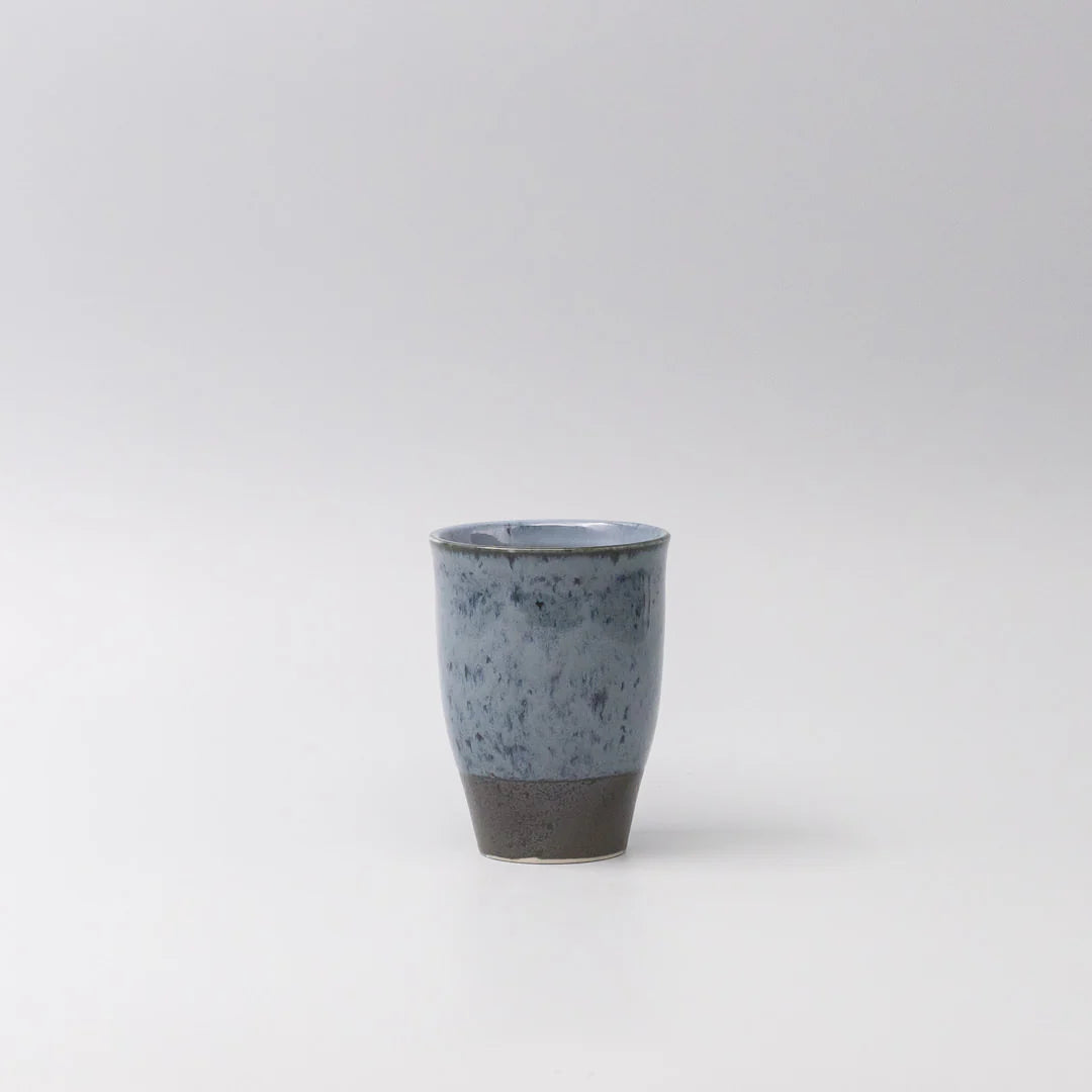 Ceramic cup with speckled design on a white background