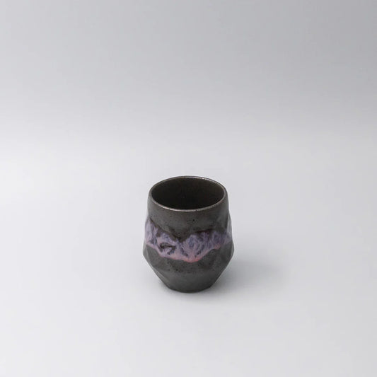 Black ceramic cup with purple interior on a white background