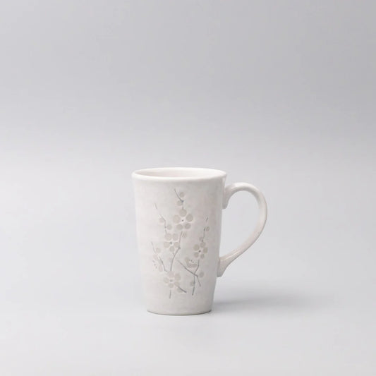White ceramic mug with embossed design on a light gray background
