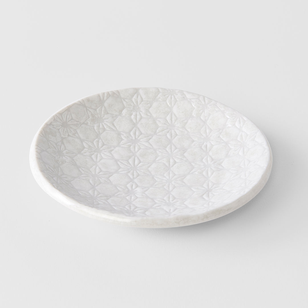 White ceramic plate with textured pattern on a light gray background