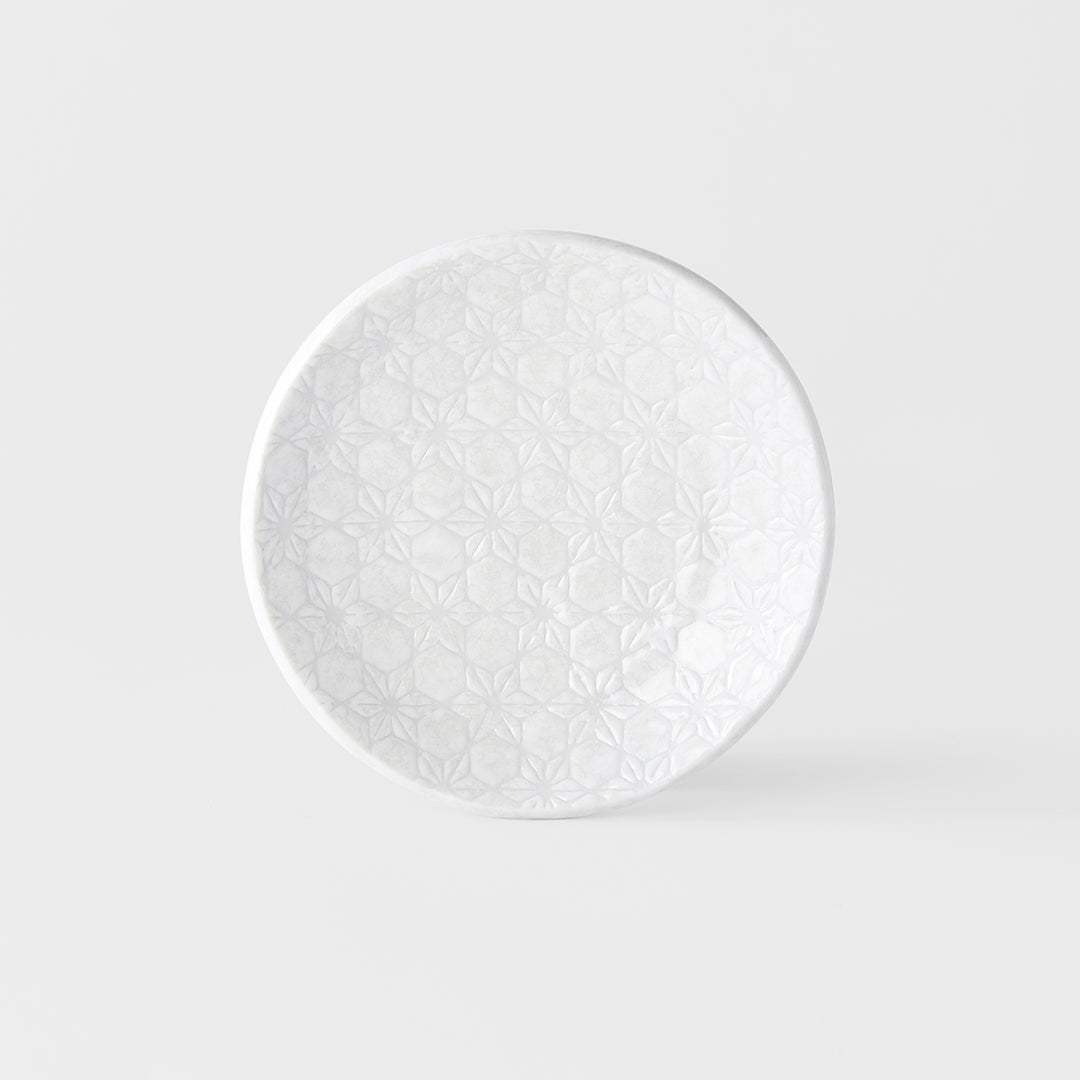White decorative plate with intricate patterns on a light gray background
