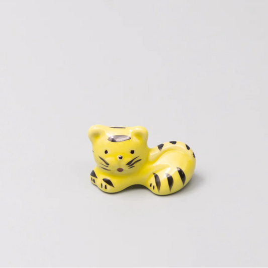 Yellow tiger figurine on a light gray background
